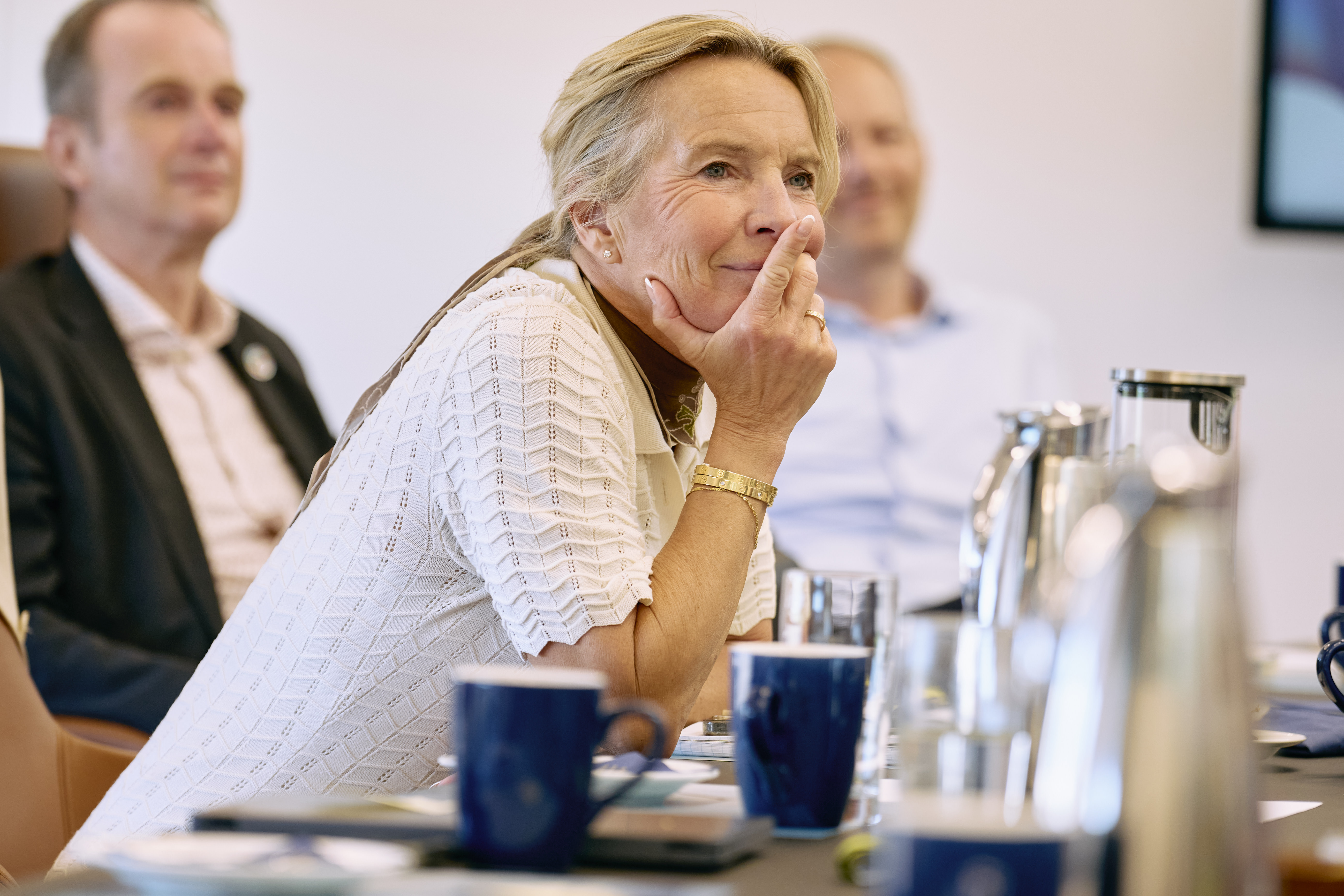 Kvinde lytter i mødelokale